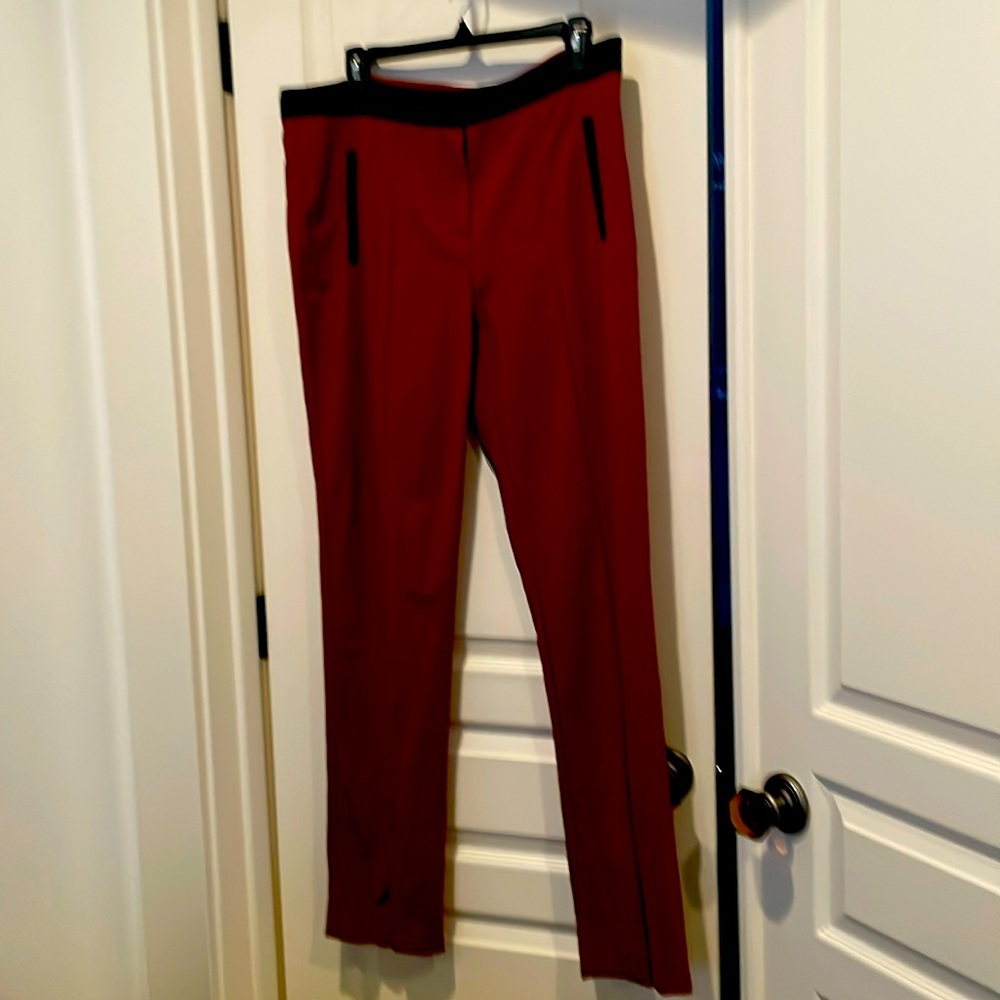 Rust colored skinny leg pant with black pocket and waist detail